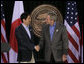 President George W. Bush exchanges handshakes with Prime Minister Shinzo Abe of Japan after their joint press availability Friday, April 27, 2007, at Camp David.  White House photo by Joyce N. Boghosian
