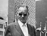 Photo of Bunche standing in front of the United Nations' building