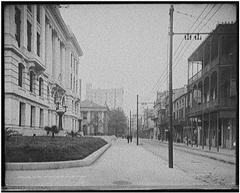 Photograph of near empty Royal Street line with buildings  and trolley lines over head.