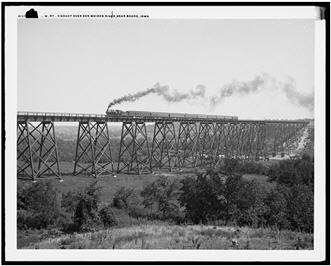 Steam engine train crossing bridge over the Des Moines River in Iowa.