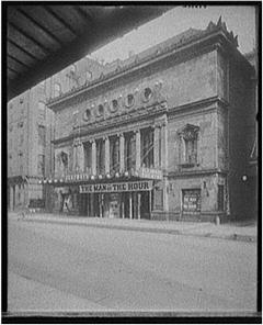 Black and white photo a theatre in Illinois with a sign reading, The Man of the Year.