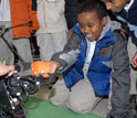 Elementary school student playing with the humanoid robot DARwIn