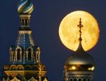 A full moon rises above a cathedral in St. Petersburg, Russia, June 14, 2006. [© AP Images]
