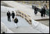 After laying a wreath in the north tower reflecting pool, President George W. Bush and Laura Bush walk through the World Trade Center site to lay a second wreath in the south tower reflecting pool to commemorate the fifth anniversary of the September 11th terrorist attacks in New York City Sunday, September 10, 2006.