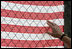 A visitor at the fence overlooking Ground Zero touches an American flag printed with names of those who were killed during the September 11th terrorist attacks Sunday, September 10, 2006. President and Mrs. Bush also visited the site Sunday to mark the fifth anniversary of the attacks. 