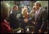 President George W. Bush talks with some of family members of those who were killed during the September 11 attacks after signing Intelligence Authorization Act in the Roosevelt Room, Wednesday, Nov. 27. The act of Congress will authorize intelligence programs and creating a national commission to investigate the events of September 11, 2001.