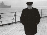 This photograph shows Churchill striding the deck of the British battleship <cite>Prince of Wales</cite>.