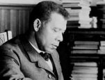 Booker T. Washington, half-length portrait, seated at desk, facing right