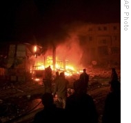 Palestinian gather as firefighters try to control a fire after an Israeli airstrike in the Rafah refugee camp, southern Gaza Strip, 15 Jan 2009