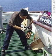 Photo released by China's Xinhua News Agency shows Chinese crew member igniting fire bomb to defend against pirate attack in Gulf of Aden, 17 Dec 2008 