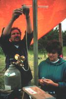 Collecting pore water from cores to identify natural attenuation processes in ground water at the Bemidji Crude Oil Spill Site, MN. The scientists are withdrawing water with a syringe from a core encased in polycarbonate tubing. The bottom of the core was frozen to prevent fluid from escaping the core. This technique allows for closely spaced samples that enable scientists to study the biogeochemical heterogeneity of contaminant plumes