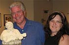 Photo: Huell Howser posing with woman and statue