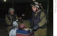Israeli soldiers evacuate a soldier, injured during an Israeli army operation in Gaza, into a hospital in Beer Sheva, southern Israel, early Sunday, 04 Jan. 2009