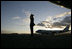 Air Force One sits on the tarmac at Osaka International Airport Wednesday, Nov. 16, 2005, as a military aide salutes the arrival of the President and Mrs. Bush.