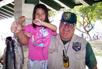 Fish and Game Volunteer with child and fish