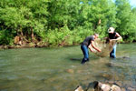 Two men in a stream with a net.