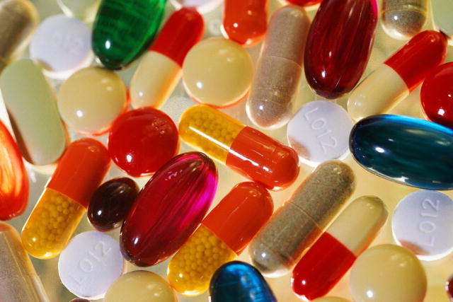 Picture depicts a colorful collection of medications, both capsules and tablets.
