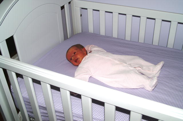 Photo of a baby sleeping in a white crib.