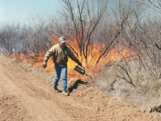 Drip torch igniting a fire