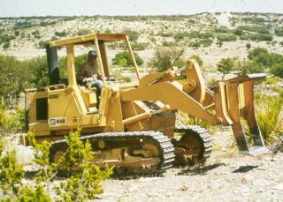 Track loader with a grubbing blade