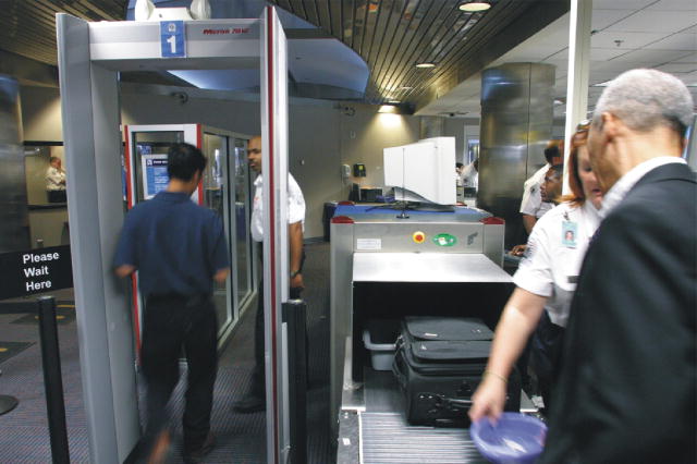  The picture shows passengers being screened at an airport checkpoint.