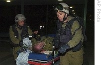 Israeli soldiers evacuate a soldier, injured during an Israeli army operation in Gaza, into a hospital in Beer Sheva, southern Israel, early Sunday, 04 Jan. 2009