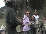 Park Ranger Kelli English holds an elk antler while three kids hold a wolf hide during a program on Yellowstone wildlife.