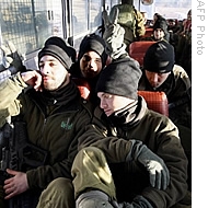 Israeli's soldiers sit in a bus after returning from the Gaza Strip on the Israeli-Gaza border, 13 Jan 2009