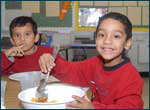 Photograph: Two children at a school lunch site.