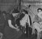 Вскоре после освобождения лагеря Берген-Бельзен медицинский персонал Второй Британской Армии организовал мероприятия по оказанию помощи в лагере. На этом снимке британская женщина помогает бывшему узнику лагеря во время примерки обуви.
