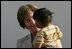 Mrs. Laura Bush smiles as she holds a child during a visit Friday, Nov. 21, 2008, to the San Clemente Health Center in San Clemente, Peru. The center serves an average of 80 patients a day in the town of 25,000 located six miles north of Pisco, the site of the August 2007, 8.0-magnitude earthquake.