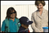 Mrs. Laura Bush and Ms. Nancy Quispitupa, Program Manager and Community Trainer, watch as 8-year-old William Sebastian Hernandez Jeri demonstrates learned hand-washing techniques Friday, Nov. 21, 2008, at the San Clemente Health Center in San Clemente, Peru. The center is the town's major health provider and serves an average of 80 patients per day.