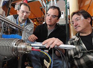 Argonne scientists Bob Scott (left), Rick Vondrasek and Gary Zinkann inspect the surface ionization source, which provides stable beams to the charge breeder