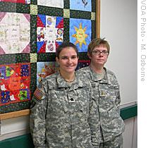 Maryann Masone (left) and Lori Skinner pose by the 2006 commemorative baby quilt; the maternity nurses create one each year