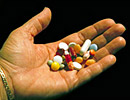 An open hand holding a variety of pills