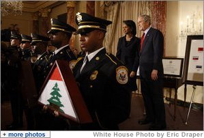 President George W. Bush and U.S. Secretary of State Condoleezza Rice stand during a presentation oft he Color Guard and the playing of the national anthem Thursday, Jan. 15, 2009, during a ceremony at the U.S. Department of State commemorating foreign policy achievements. White House photo by Eric Draper