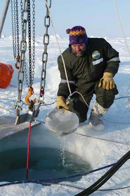 Arctic researcher collects sea water samples from sea ice