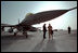 Standing under a F-16 fighter jet, Vice President Dick Cheney talks with an Air Force pilot during a tour of the Al-Udeid Airbase in Qatar, March 17, 2002.