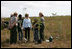 Mrs. Laura Bush joins Florida City Elementary School students Cornesha Dericho, left, and Dania Amaya, along with park ranger Allyson Gantt, right, as they prepare to plant a Gumbo Limbo tree Wednesday, Feb. 6, 2008, during the Junior Ranger "First Bloom" planting event in Everglades National Park, Fla. Mrs. Bush praised the Everglades restoration program which hopes to plant native trees to replace invasive species that are choking the park.