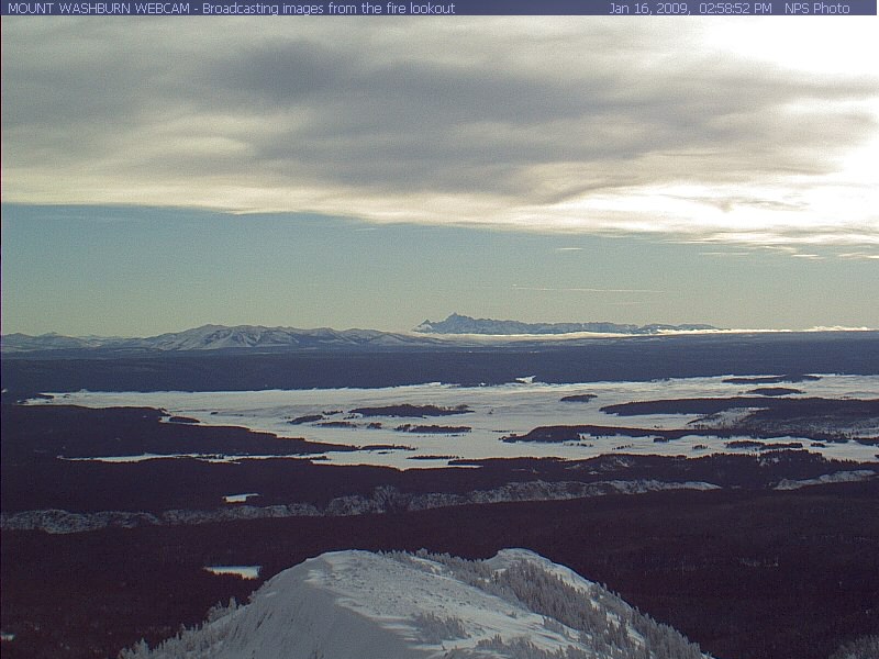 Mt. Washburn webcam image shows of a view of Hayden Valley, Grand Canyon of the Yellowstone, a portion of Yellowstone Lake, and the Tetons in the distant background.