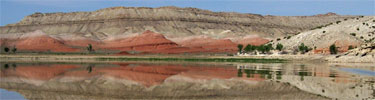 Red, chugwater hills reflect off the water near the South Narrows