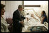 President George W. Bush shakes the hand of SPC Jeremy Goodman of Washington, N.C., as his wife, Terry Goodman, looks on Wednesday, Oct. 5, 2005, during a visit by the President and Mrs. Bush to Walter Reed Army Medical Center in Washington D.C.