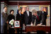 President George W. Bush signs a condolence book for the victims of the recent tsunami during a visit to the Embassy of Thailand in Washington, D.C., Monday, Jan. 3, 2005. Next to the book, stands a photograph of Khun Poom Jensen, 21. A grandson of Thailand's King Bhumibol Adulyadej, Mr. Jensen died in the tsunami. Also signing their condolences are Laura Bush and former Presidents Bush and Clinton.