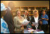 Mrs. Laura Bush and Senegal’s First Lady Viviane Wade look through schoolbooks donated by Elizabeth City State University during a visit to Grand Medine Primary School Tuesday June 26, 2007, in Dakar, Senegal. The books were donated through the Africa Education Initiative textbook program, which partners together African and American institutions.