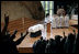 The 'Hooke' em horns' sign is given by mourners at the conclusion of the funeral service for former first lady Lady Bird Johnson Saturday, July 14, 2007, at the Riverbend Center in Austin, Texas.