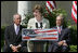 Mrs. Laura Bush is joined by U.S. Secretary of the Interior Dirk Kempthrone, left, and Jon Nau III, chairman of the Advisory Council on Historic Preservation, as she addreses guests in the White House Rose Garden, Wednesday, May 9, 2007, during the Preserve America President Awards ceremony.