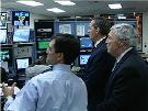 Secretary Leavitt and Commissioner von Eschenbach looking at monintors in a FedEx control room. HHS Photo by Holly Babin