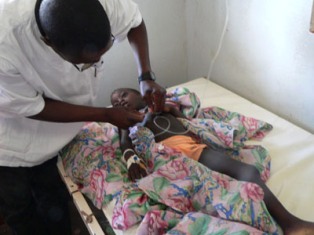 A doctor attends to a young boy affected by malaria in Africa. Photo: USAID