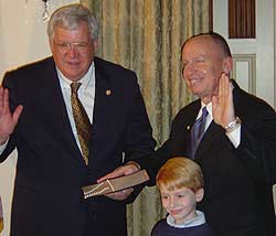 Congressman Kevin Brady is sworn into office for the 109th Congress by House Speaker Dennis Hastert.   Congressman Brady's son Will is also pictured. 