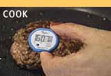 Cook: Ground Beef being cooked showing a meat thermometer at 160 degrees F.